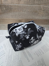 Load image into Gallery viewer, Black floral-patterned bag on a wooden surface with text underneath