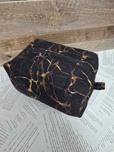 Load image into Gallery viewer, black cosmetic bag with brown marble design on wood background