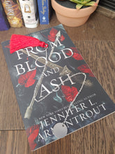 Load image into Gallery viewer, silver chain bookmark with red tassel on top of a book