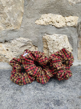 Load image into Gallery viewer, A flannel scrunchie with a plaid pattern, displayed on a stone surface.