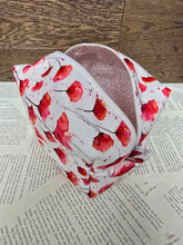 Load image into Gallery viewer, top view of cosmetic bag abstract red and pink poppy flower with black stem on white back ground with white zipper pale pink polka dot inner lining 
